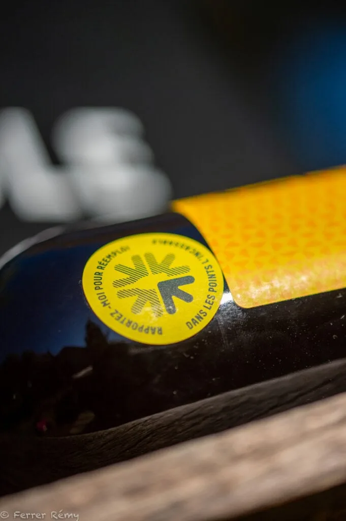 Accueil 7 Bouteille de bière artisanale avec étiquette de mise en garde sanitaire, ambiance chaleureuse.